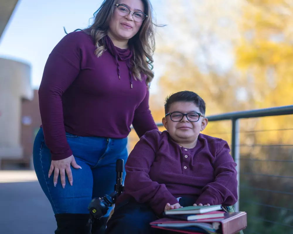 Smiling disabled man with support worker both looking and smiling at camera